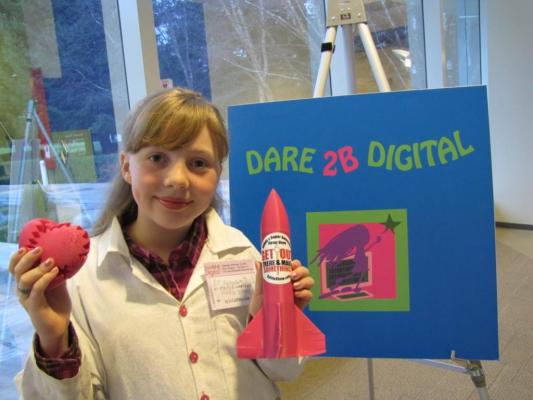 Sylvia stands in front of the Dare 2B Digital Sign