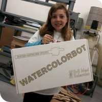 Sylvia posing with her custom made white cardboard box that reads "Super-Awesome Sylvia - WATERCOLORBOT - Evil Mad Scientist"