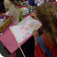 Sylvia paints onto her "Freak Flag" at the Fly Your Freak Flag High booth