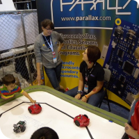 Sylvia playing with the bots at the Parallax booth with Jessica Uelmen & Emily Kurze 