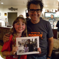 Sylvia posing with Mark Frouenfelder, with a picture of them in 2010