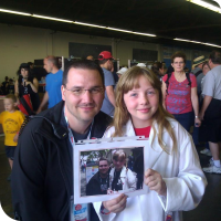 Sylvia posing with Marc De Vinck, with a picture of them last year