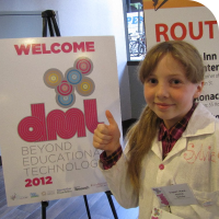 Sylvia gives two thumbs up in front of the DML 2012 Sign in the hotel lobby