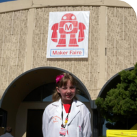 Sylvia standing in front of the Maker Faire sign in San Mateo, California