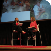 Event organizer Diane Michlig on the left, and Sylvia on the right, talking on stage at TEDx San Jose