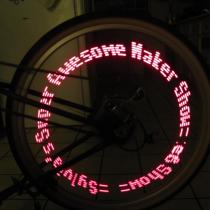 MiniPOV writes a red visible message in a long exposure of a bicycle wheel