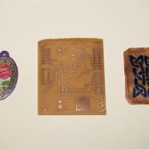 Etched pieces of copper and a circuit board on a white background.