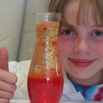 Sylvia gives a thumbs up next to her glass vase lava lamp