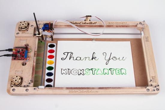 Thank you Kickstarter! You guys rock the bot! SYlvia's Water Color Robot witht he words "Thank You Kickstarter" painted on a piece of paper at Evil Mad Scientist Headquarters.