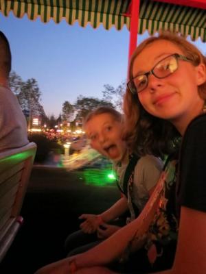 Sylvia smiling while riding next to her sister Talulah through Disneyland.
