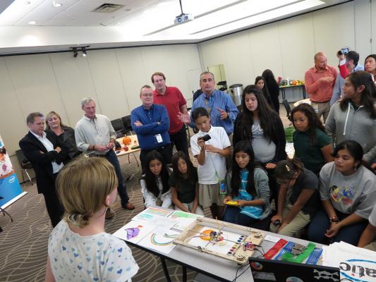 Sylvia talking to a group of girls, Intel employees and the Intel CEO about the WaterColorBot and Intel headquarters.