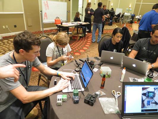 Sylvia dissasembles a Cubelet robot at the hacking table to extract a servo while at RobotsConf 2013 in Florida.