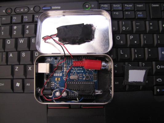 The alarm consists of an arduino, a small red laser diode, an IR led (from a remote) and a speaker The ALTAlarm inside a mint tin