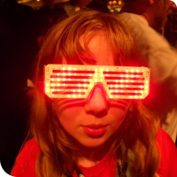 Sylvia posing with bright red LED matrix glasses displaying a hypnotizing pattern.