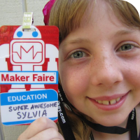 Sylvia posing with her preliminary Maker Faire Badge