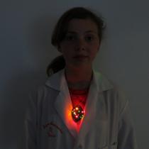 Sylvia standing with the pendant glowing during one of her heart beat pulses.